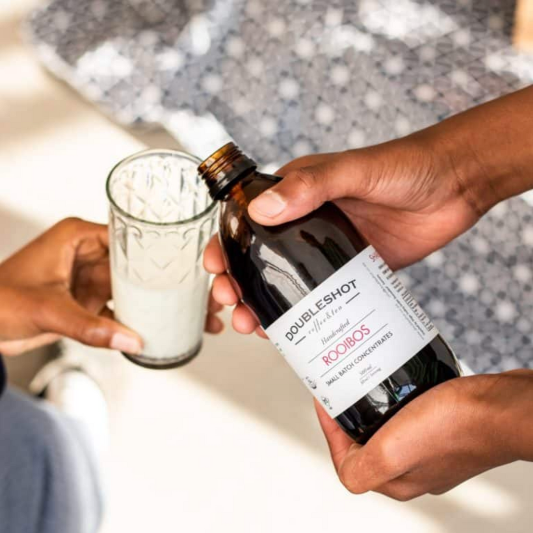 Glass bottle of Double Shot Rooibos Tea Concentrate with honey and vanilla, featuring a rich amber color