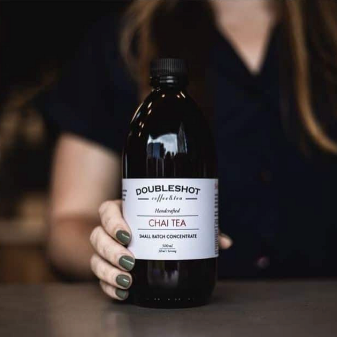 Glass bottle of Double Shot handcrafted chai concentrate with spices and a rich amber color