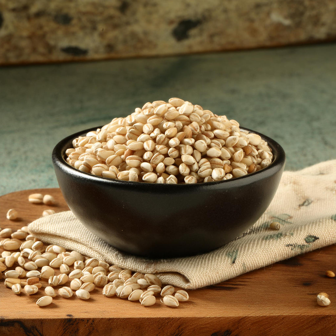 AGT pearled barley grains in a clear bag, showcasing their light tan color and whole grain texture.