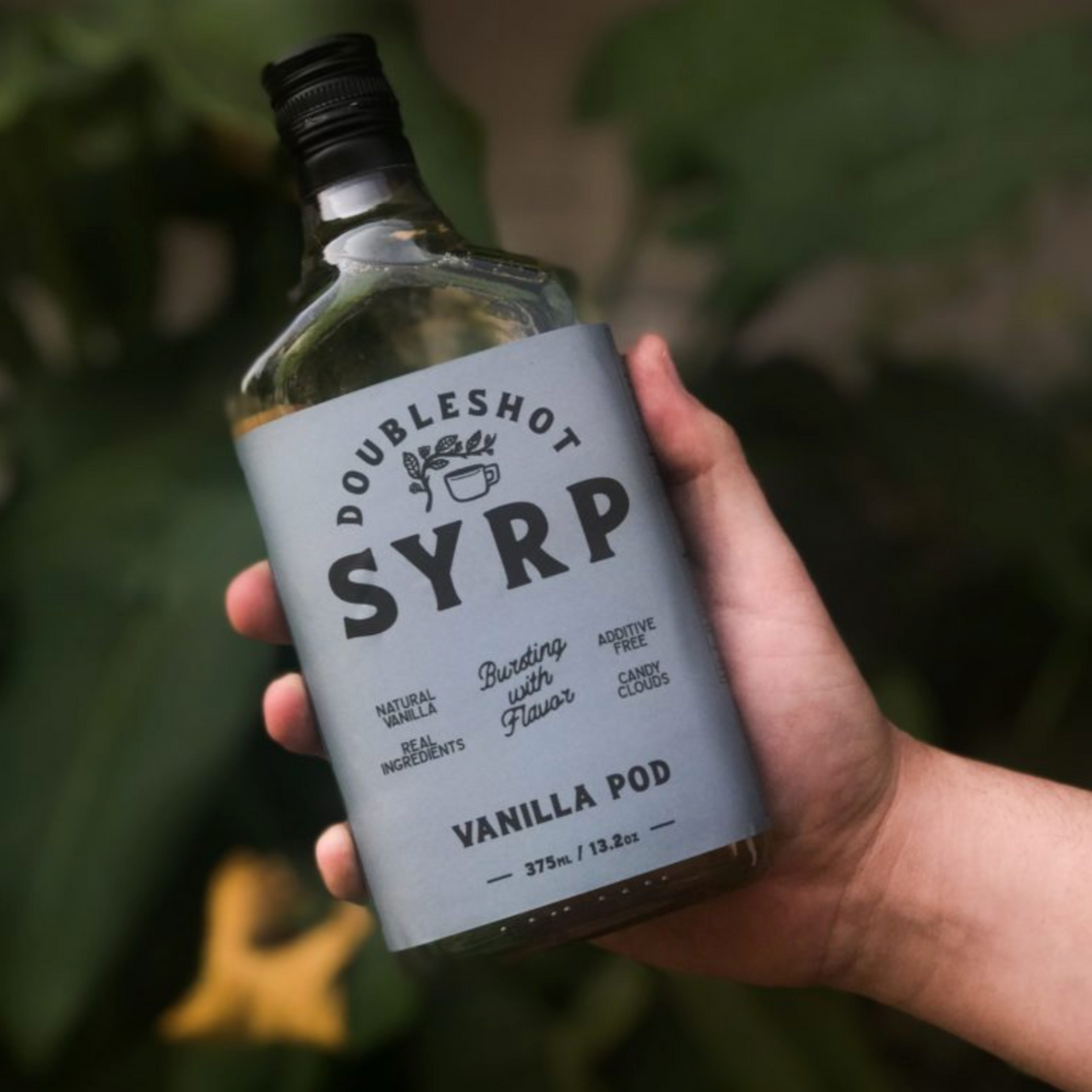 Artisanal coffee syrup bottle with African vanilla beans, branded Double Shot, showcasing a rich amber color