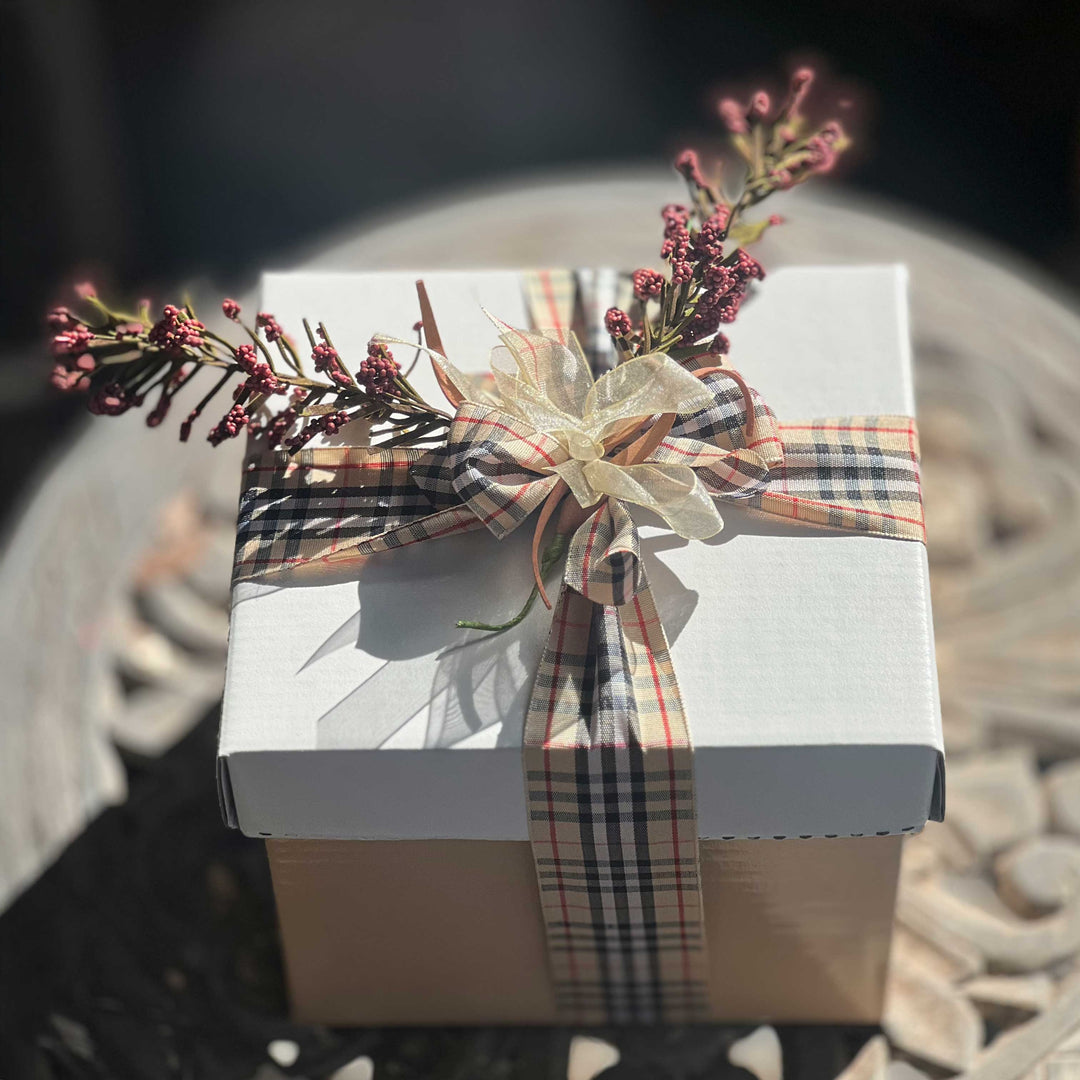 Mini-Gift-Box-Sweet-Savory delicious and caring and thoughtful treat for any occasion
Gift basket with various items including a mini oil bottle, chocolate, various spices, tea towel and wrapped packages on white tissue paper.