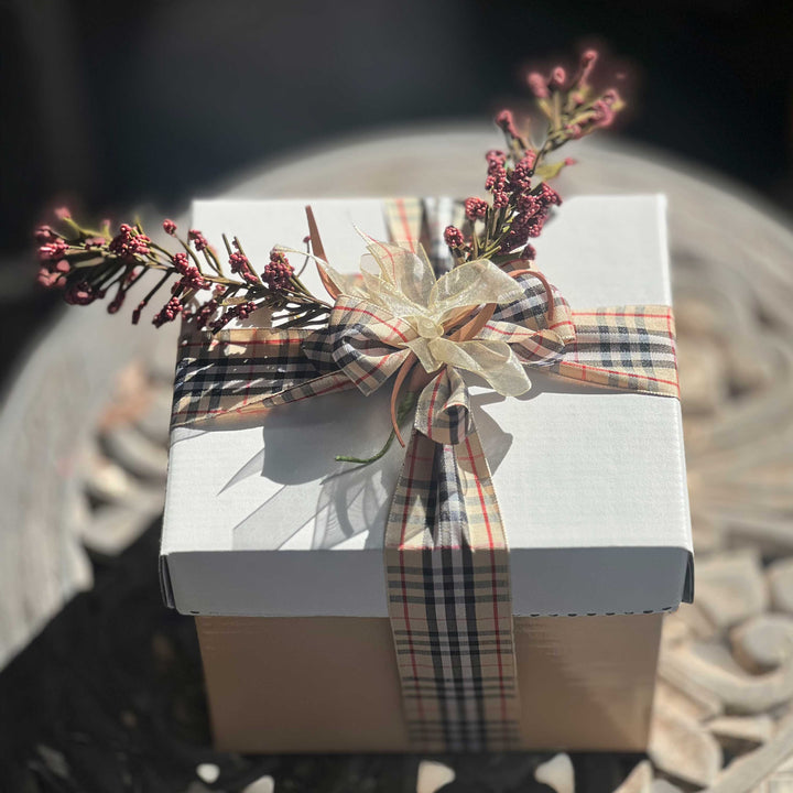 Mini-Gift-Box-Sweet-Savory delicious and caring and thoughtful treat for any occasion
Gift basket with various items including a mini oil bottle, chocolate, various spices, tea towel and wrapped packages on white tissue paper.