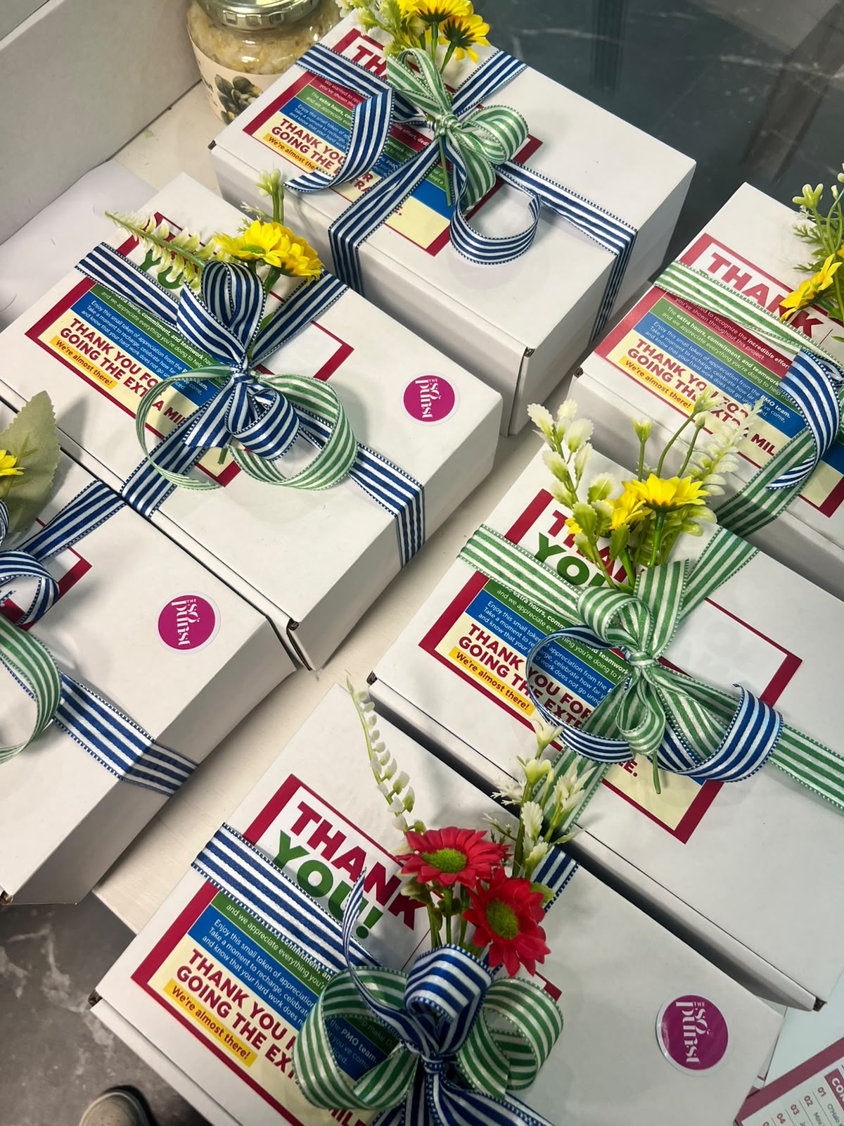 SoPurist corporate thank-you gift boxes finished with striped ribbon and flowers